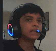 a young boy is wearing headphones with a microphone in his mouth .