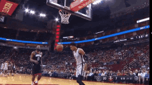 two basketball players are fighting with a referee during a game sponsored by proud banking partner of the houston rockets