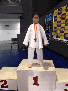 a young girl is standing on a podium with the number 1 on it