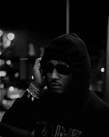 a black and white photo of a man wearing a hoodie