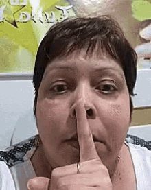 a woman is making a shhh sign with her finger to her mouth