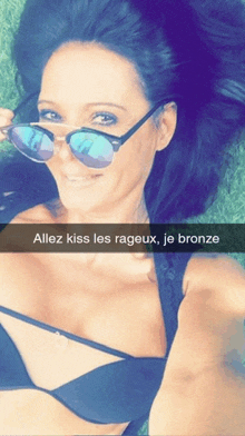 a selfie of a woman wearing sunglasses with the caption " allez kiss les rageaux je bronze "