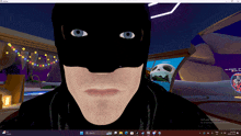 a computer screen shows a man wearing a batman mask with blue eyes