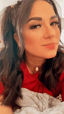 a woman wearing a red shirt and a choker necklace