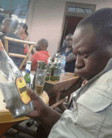 a man sits at a table with a bottle of kahlua