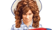 a woman with curly hair is wearing a straw hat and holding a red and blue frisbee .