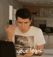 a man wearing a t-shirt that says " your logic " on it