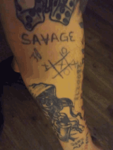 a tattoo on a person 's leg says savage