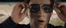 a close up of a man wearing glasses and a surprised look on his face .