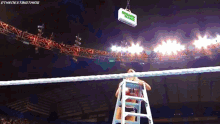 a man on a ladder in a wrestling ring with a sign that says money in the bank above him