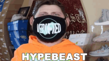 a man wearing an orange hoodie and a black mask with the word hypebeast on it