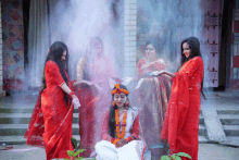 a woman in a red dress is surrounded by other women in red dresses