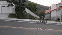 a man is riding a bike down a street with a sign that says ' no parking ' on it