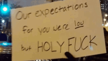 someone is holding a sign that says our expectations for you were low but holy fuck