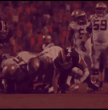 a football player with the number 59 on his jersey is kneeling down on the field