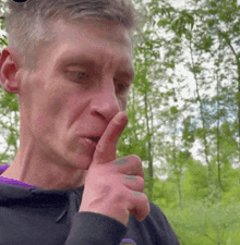 a man is holding his finger to his mouth and making a silence sign