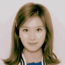 a close up of a woman 's face with brown hair and a blue shirt