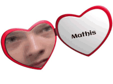 a heart shaped mirror with a man 's face and the name mathis on it