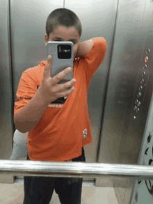 a boy is taking a selfie in an elevator .