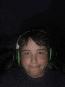 a boy wearing a pair of green headphones