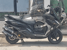 a black euroman scooter is parked on the sidewalk