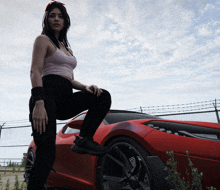 a woman kneeling on a red sports car