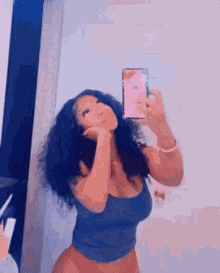 a woman is taking a selfie in a mirror .