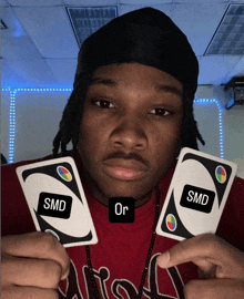 a man is holding two uno cards that say smd on them