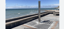 a picture of a beach with a brick wall and a stainless steel shower