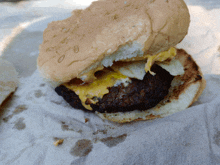 a close up of a hamburger with eggs and cheese