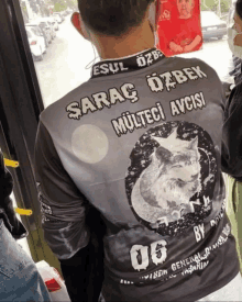 a man wearing a shirt that says ' saray ozbek ' on the back