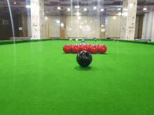 a pool table with red and black pool balls on it