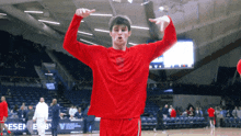 a man in a red shirt is standing on a basketball court in front of a sign that says regeney