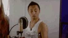 a man is singing into a microphone in a recording studio .