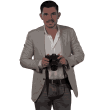 a man holding a camera with a canon strap