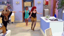 a woman with red hair is dancing with two other women in a room