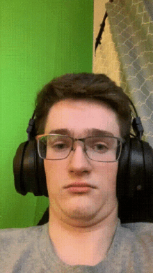 a man wearing glasses and headphones is making a face