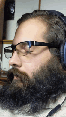 a man with glasses and a beard is wearing headphones and a microphone