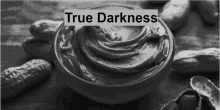 a bowl of peanut butter is surrounded by peanuts and the words true darkness