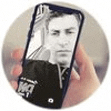 a person is holding a cell phone with a picture of a man on the screen .