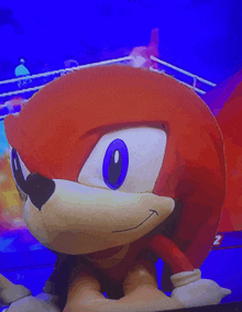 a close up of knuckles the hedgehog 's face with a blue background