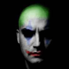 a close up of a man 's face with a clown makeup on .