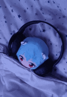 a stuffed animal with red eyes is laying on a bed with headphones