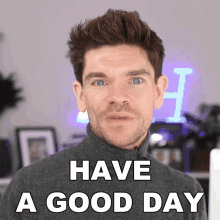 a man says have a good day in front of a neon sign