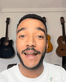 a man with a beard is smiling in front of a wall of guitars with tiktok written on the bottom right