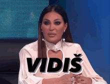 a woman sitting in front of a blue screen with the word vidis on it