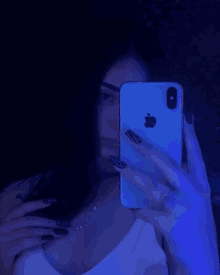 a woman taking a picture of herself in the mirror with an apple phone