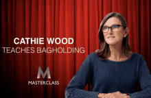 a woman stands in front of a red curtain with the name cathie wood on it