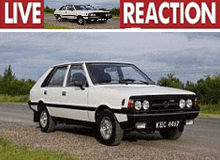 a white car is parked on the side of a road next to a live reaction sign