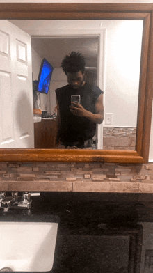 a man takes a selfie in a bathroom mirror